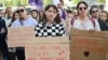 A protestor holds a placard reading "'There's rape and rape' and there's my hand in your face" during a demonstration in support of Gisele Pelicot in Rennes, France, Sept. 14, 2024. 