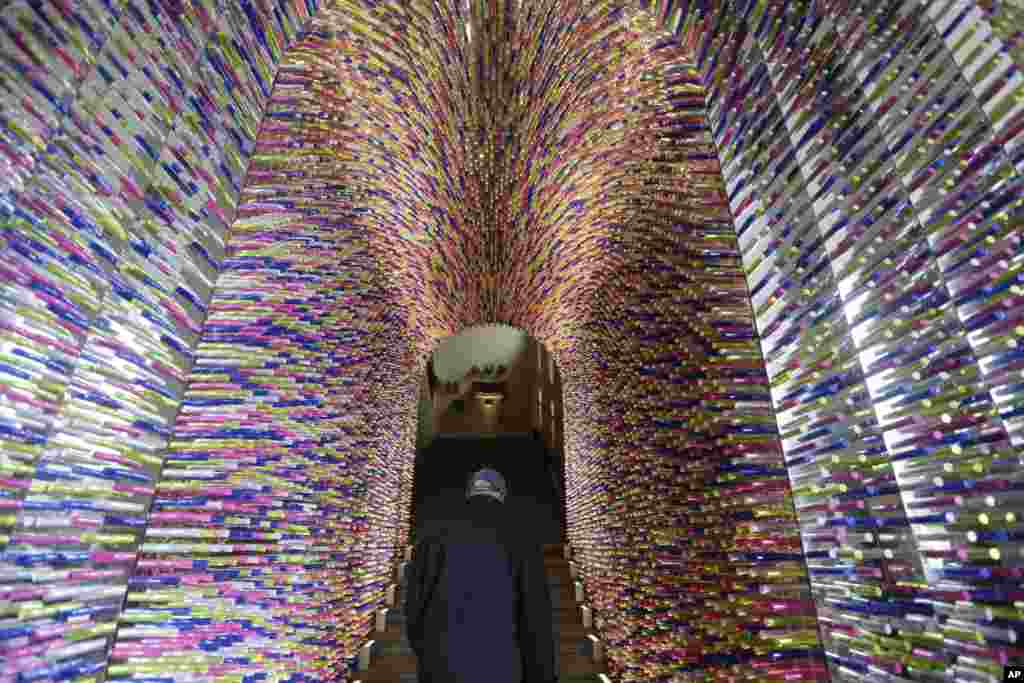 A man passes under an installation called &quot;Transition&quot;, made with lipstick packages, part of the Milan&#39;s Furniture Fair, in Milan, Italy, Apr. 8, 2012. The 52nd International Furniture Fair (Salone del Mobile) opens in Milan until April 14. 