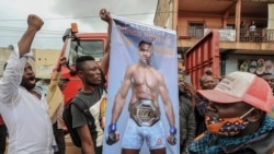 Une banderole à l'effigie du Camerounais Francis Ngannou, champion du monde des arts martiaux mixtes poids lourds (MMA), alors qu'il conduisait dans les rues de Bafoussam, au Cameroun, le 1er mai 2021, pour présenter sa ceinture de championnat.