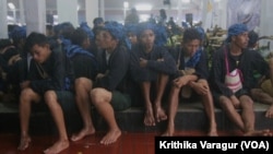 Baduy men wait out the rain at the regent's office in Rangkasbitung, Indonesia.