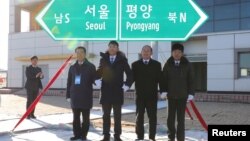 South and North Korean officials unveil the sign of Seoul to Pyeongyang during a groundbreaking ceremony for the reconnection of railways and roads at the Panmun Station in Kaesong, North Korea, Dec. 26, 2018.