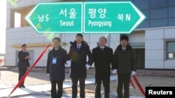 South and North Korean officials unveil the sign of Seoul to Pyeongyang during a groundbreaking ceremony for the reconnection of railways and roads at the Panmun Station in Kaesong, North Korea, Dec. 26, 2018. (Yonhap via Reuters)