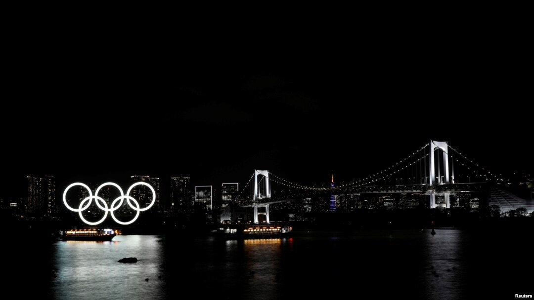 Kapal-kapal melintas di depan cincin-cincin raksasa Olimpiade di kawasan Odaiba Marine Park di Tokyo, Jepang, 2 April 2021.