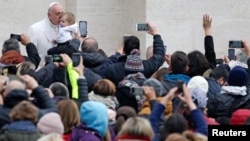 Pope Francis kisses a baby as he leads the weekly general audience in Saint Peter's Square at the Vatican, Feb. 22, 2017. 
