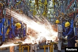 Employees work along a production line at a factory of Dongfeng Nissan Passenger Vehicle Co. in Zhengzhou, Henan province, China, Nov. 12, 2015.