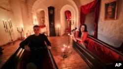 Tami Varma (R) and her brother Robin, grandchildren of an expert in vampire lore, pose in coffins at Dracula's Castle, in Bran, Romania, Oct. 31, 2016. The pair bested 88,000 people in a competition to win the chance of a night at the famed landmark.