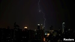 Lightning is seen above buildings during a storm in central Shanghai, China, August 7, 2017. 