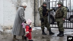 A woman accompanies her child to be evacuated from Avdiivka to Sviatohirsk, a town about 140 kilometers (88 miles) away and far from the conflict front line, in eastern Ukraine, Feb. 5, 2017. A sharp escalation in fighting between Ukrainian troops and Russia-backed rebels in the previous week had killed at least 33 people, centering on Avdiivka, a government-held town just north of rebel-controlled Donetsk.