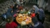 Sebuah keluarga Palestina menikmati Iftar, makanan berbuka puasa, selama bulan Ramadan di apartemen mereka yang rusak di Jabaliya, Jalur Gaza utara (foto: ilustrasi). 