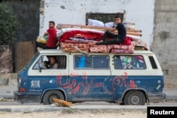 Palestinos desplazados viajan en un vehículo mientras huyen de Rafah, después de que las fuerzas israelíes lanzaran una operación terrestre y aérea en la parte oriental de la ciudad meridional de Gaza, el 12 de mayo. 2024. REUTERS/Hatem Khaled