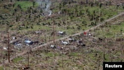 FILE - An aerial view of a coconut plantation and houses in a village destroyed by Typhoon Haiyan in Tolosa, Leyte in central Philippines, Nov. 19, 2013.