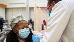 Juanta J. Gordon, left, receives the Moderna coronavirus vaccine from her daughter, nurse Zyra D. Gordon Smith, at Trinity United Church of Christ in Chicago, Illinois, Feb. 13, 2021.