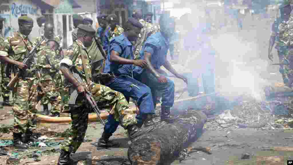 Abapolisi n’abasirikare bariko barakuraho ivyazibiye amabarabara vyashizweho n’abari mu myiyerekano y’ukwiyamiriza Reta muri Kimone ya Cibitoke ku murwa mukuru w’Uburundi, Bujumbura, ku musi wa mbere, italiki 25 z’ukwezi kwa gatanu, umwaka w’2015.