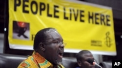 Amnesty International 's Kenya director, Justus Nyang'aya gestures as he addresses the media in Nairobi on forced evictions of people from urban slums across Africa, March 22, 2012. 