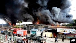 Para petugas pemadam kebakaran berupaya memadamkan api yang menghancurkan rumah-rumah penduduk, sementara tentara pemerintah terus memerangi pemberontak muslim di kawasan Zamboanga, Filipina selatan (12/9).