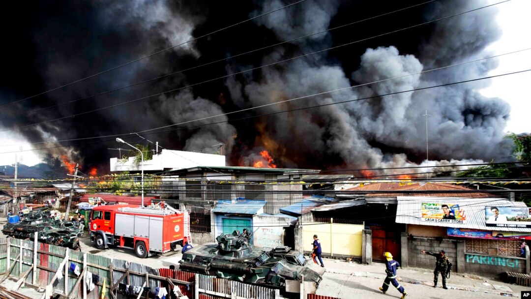 Para petugas pemadam kebakaran berupaya memadamkan api yang menghancurkan rumah-rumah penduduk, sementara tentara pemerintah terus memerangi pemberontak muslim di kawasan Zamboanga, Filipina selatan (12/9).
