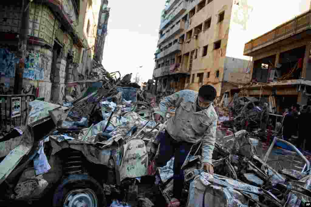 An Egyptian man makes his way through rubble at the scene of an explosion at a police headquarters building in the Nile Delta city of Mansoura, Egypt, Dec. 24, 2013. 