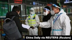 봉쇄된 중국 시안의 철도역에서 공안 요원과 당국자들이 이동 중인 시민의 방역 증명 등을 살펴보고 있다. 