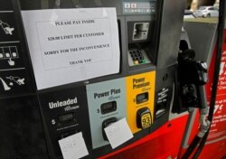 FILE - A gasoline station posts signage saying that it has run out of unleaded and mid-grade fuel and has a $20 limit on super, following a ransomware attack on Colonial Pipeline, at the pump in Atlanta, May 11, 2021.