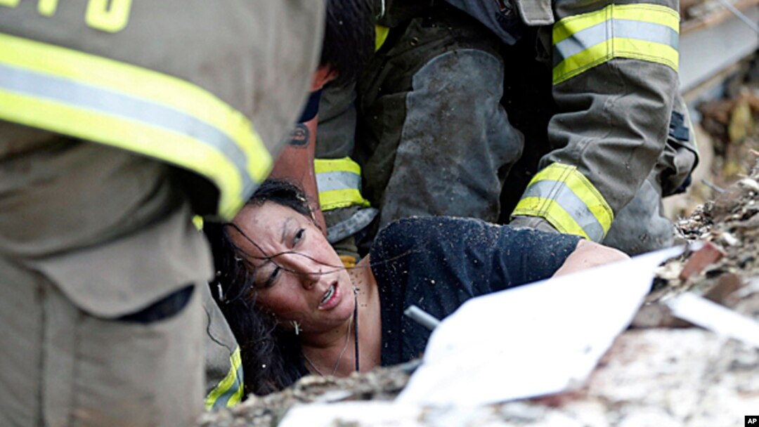 A woman is pulled out from under tornado debris at the Plaza Towers School in Moore, Oklahoma, May 20, 2013. 