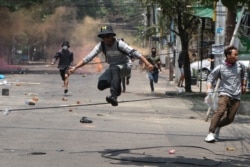 Anti-coup protesters run to avoid military forces during a demonstration in Yangon, Myanmar, March 31, 2021.