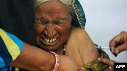 An elderly woman reacts as she is inoculated with the COVID-19 coronavirus vaccine at a government hospital on the outskirts of Ajmer, India, on March 6, 2021.