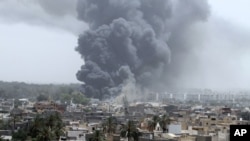 Smoke rises after coalition air strikes in Tripoli June 7, 2011.