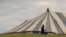 FILE - A man carrying a bag walks past a large unoccupied church marquee after Easter Weekend celebrations were cancelled due to lockdown to prevent the spread of coronavirus, at Katlehong near Johannesburg, South Africa, April 10, 2020, 