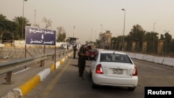 FILE - Iraqi security forces search vehicles at a checkpoint as cars cross into the Green Zone in Baghdad, Iraq, Oct. 5, 2015. The zone houses government buildings and foreign embassies, including that of the United States.