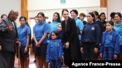 New Zealand's Prime Minister Jacinda Ardern (C) is welcomed by students from Te Wharekura O Manurewa school prior to receiving her first dose of the Covid-19 vaccine at the Manurewa vaccination center in Auckland on June 18, 2021. 