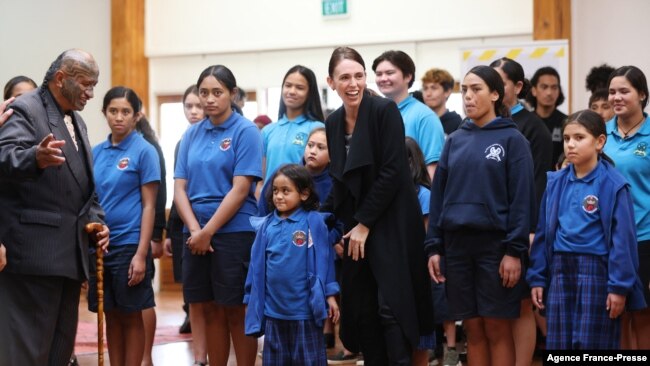 New Zealand's Prime Minister Jacinda Ardern (C) is welcomed by students from Te Wharekura O Manurewa school prior to receiving her first dose of the Covid-19 vaccine at the Manurewa vaccination center in Auckland on June 18, 2021.