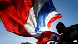 An anti-government protester waves a Thai national flag during a rally in downtown Bangkok, Thailand, May 9, 2014. 