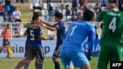 Pemain depan Jepang, Yuya Osako (kiri-belakang) diberi selamat oleh bek Jepang, Yuto Nagatomo (5) dan pemain depan Takumi Minamino (tengah-kanan) dalam laga penyisihan Grup F, Piala Asia 2019 antara Jepang dan Turkmenistan di Stadion al-Nahyan, 9 Januari 2019. 