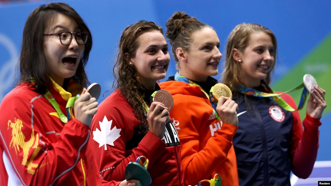 Fu Yuanhui (kiri) dan para perenang Olimpiade lainnya berpose dengan medali mereka setelah beradu di kompetisi gaya punggung 100m putri Senin (8/8).