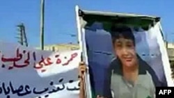 An image grab taken from YouTube on May 28, 2011, shows a Syrian man holding a picture of 13-year-old boy Hamza al-Khatib during his funeral on May 25, 2011 in the flashpoint region of Daraa, Syria.