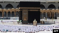 Masjidil Haram di Mekah beroperasi dengan kapasitas penuh pada 17 Oktober 2021. Jamaah melakukan ibadah salat secara berdempetan untuk pertama kalinya sejak pandemi virus corona dimulai. (Foto: AFP)