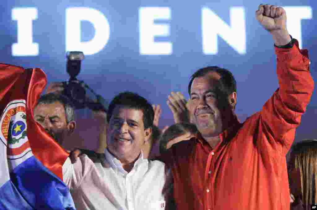 Colorado Party's presidential candidate Horacio Cartes and VP-elect Juan Afara, wave to supporters in Asuncion, Paraguay, April 21, 2013. Cartes won a five-year term over Efrain Alegre of the Radical Liberal party.
