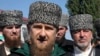 Chechen regional leader Ramzan Kadyrov, center, talks to the media, outside a polling station during parliamentary elections in Chechen town of Tzentoroi, Russia, Sept. 18, 2016.