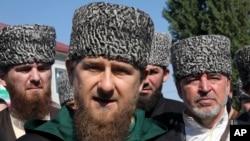 Chechen regional leader Ramzan Kadyrov, center, talks to the media, outside a polling station during parliamentary elections in Chechen town of Tzentoroi, Russia, Sept. 18, 2016.