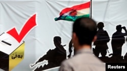 A man looks at a banner supporting the referendum for independence of Kurdistan in Erbil, Iraq, Sept. 24, 2017.