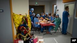 Médicos y enfermeras comparten una comida de Nochebuena en la unidad de cuidados intensivos COVID-19 en el hospital la Timone en Marsella, sur de Francia, el viernes 24 de diciembre de 2021. (Foto AP / Daniel Cole)