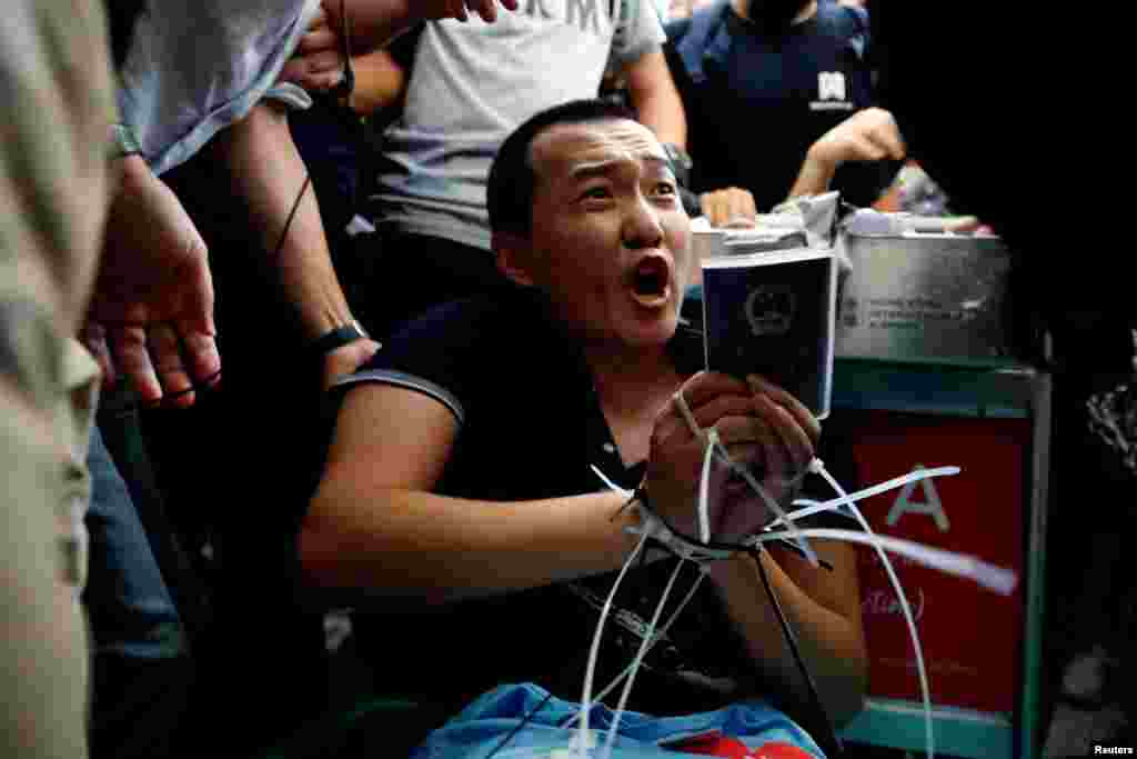 Fu Guohao, a reporter of Chinese media Global Times website, is tied by protesters during a mass demonstration at the Hong Kong international airport, in Hong Kong.