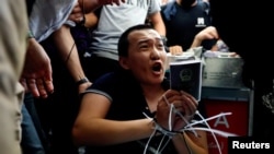 香港抗議者在國際機場示威期間捆綁並圍攻他們懷疑是中國便衣人員的《環球時報》記者傅國豪。(2019年8月13日)