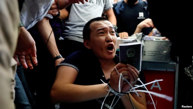 香港抗议者在国际机场示威期间捆绑并围攻他们怀疑是中国便衣人员的《环球时报》记者傅国豪。(2019年8月13日)