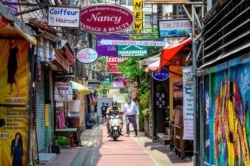 Seorang polisi berpatroli dengan mengendarai sepeda motor di kawasan bisnis hiburan dan pariwisata di Bangkok, saat pemerintah menutup lokasi ini di tengah pandemi COVID-19, 8 April 2021. (Foto: ANTONOV / AFP)