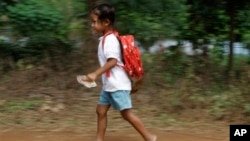 A Cambodian school girl runs home after her morning primary school in Rokar Tnong village on the outskirts of Phnom Penh, Cambodia, Thursday, Oct. 6, 2011. (AP Photo/Heng Sinith)