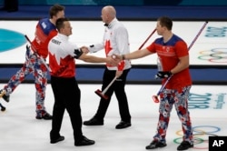 Norway's Christoffer Svae, right, shakes hands with Canada's Ben Herbert after their match at the 2018 Winter Olympics in Gangneung, South Korea, Feb. 15, 2018. At the Pyeongchang Olympics, curlers and their fans agree: In an era of vitriol and venom, curling may be the perfect antidote to our troubled times.