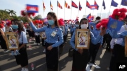 Cambodian students, holding the portrait of King Norodom Sihamoni, participate in the country's 67th Independence Day celebration, in Phnom Penh, Cambodia, Monday, Nov. 9, 2020. (AP Photo/Heng Sinith)