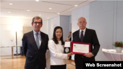 北京人权律师余文生的妻子许艳在领奖后与德法两国大使合影。(推特截图)
