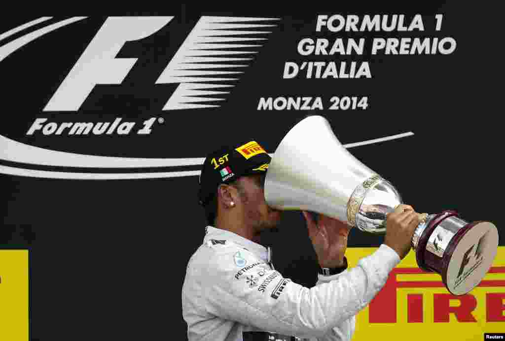 Mercedes Formula One driver Lewis Hamilton of Britain drinks champagne from his winner&#39;s trophy after winning the Italian F1 Grand Prix in Monza, Italy.